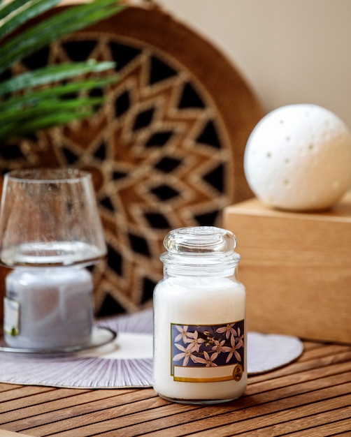 Side view of vanilla scented candle in glass on wooden table