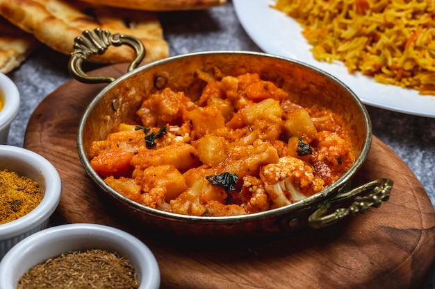 Side view vegetable ragout with potato carrot and cauliflower and basil