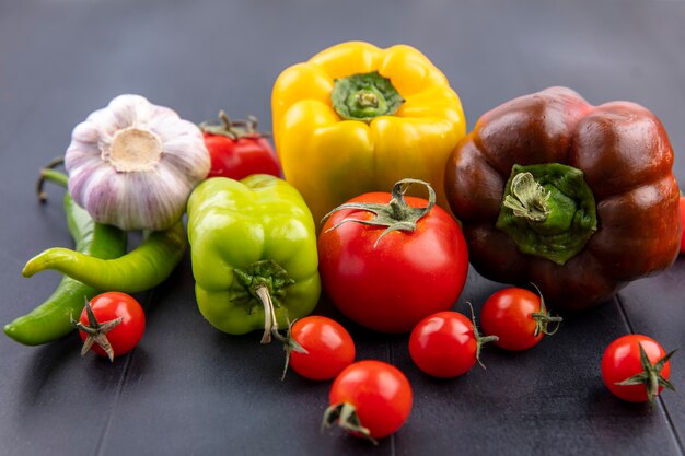 Side view of vegetables as garlic pepper tomato on black