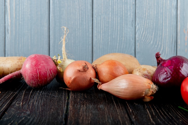 Side view of vegetables as radish and onion on wooden surface and background with copy space
