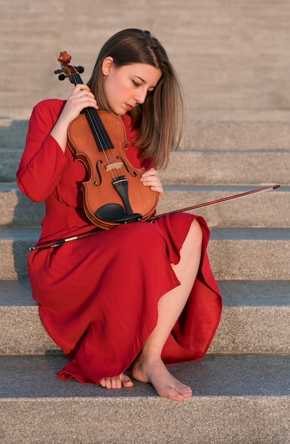 Free photo side view of violinist on steps