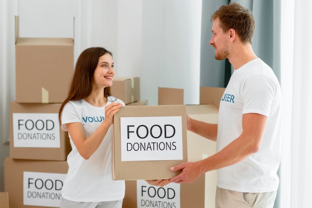 Side view of volunteers handling boxes with food donations