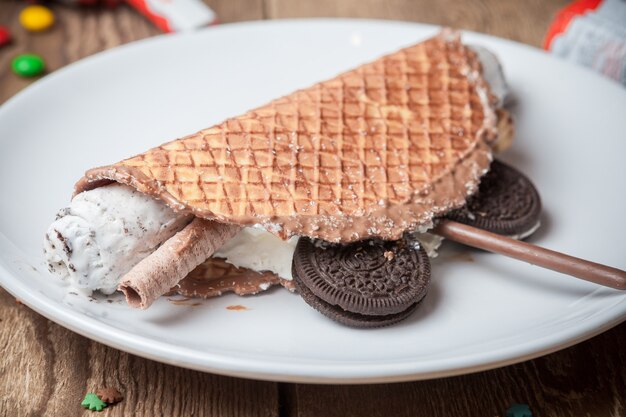 丸い白いプレートにチョコレートチップクッキーとサイドビューワッフルアイスクリーム
