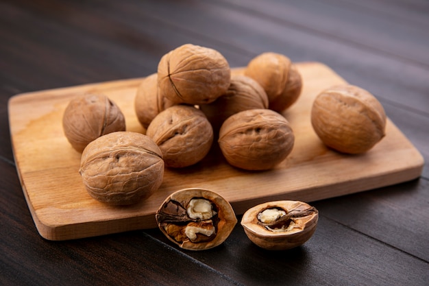 Side view of walnuts on a blackboard on a wooden surface