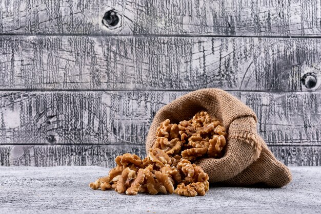 Side view walnuts in sack on stone table horizontal