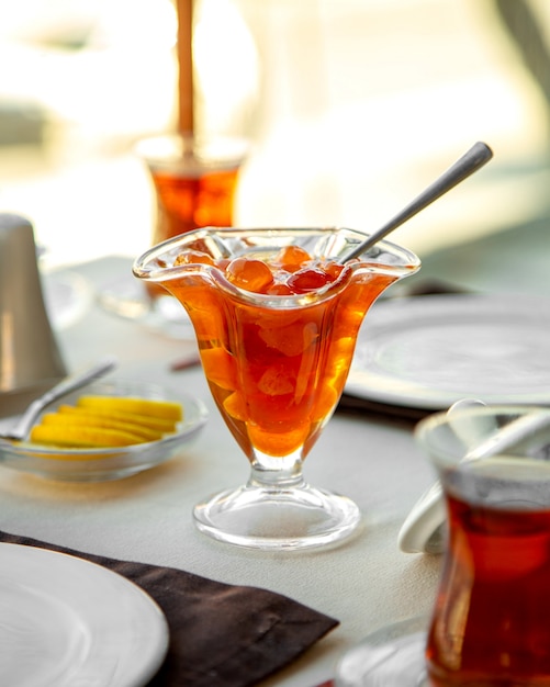 Side view of white cherry preserve served with black tea on the table