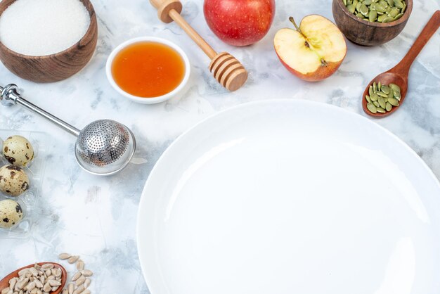 Side view of white empty plate and ingredients for the healthy foods on ice table