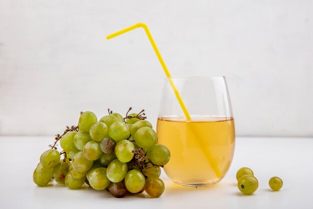 Side view of white grape and grape juice in glass on white background