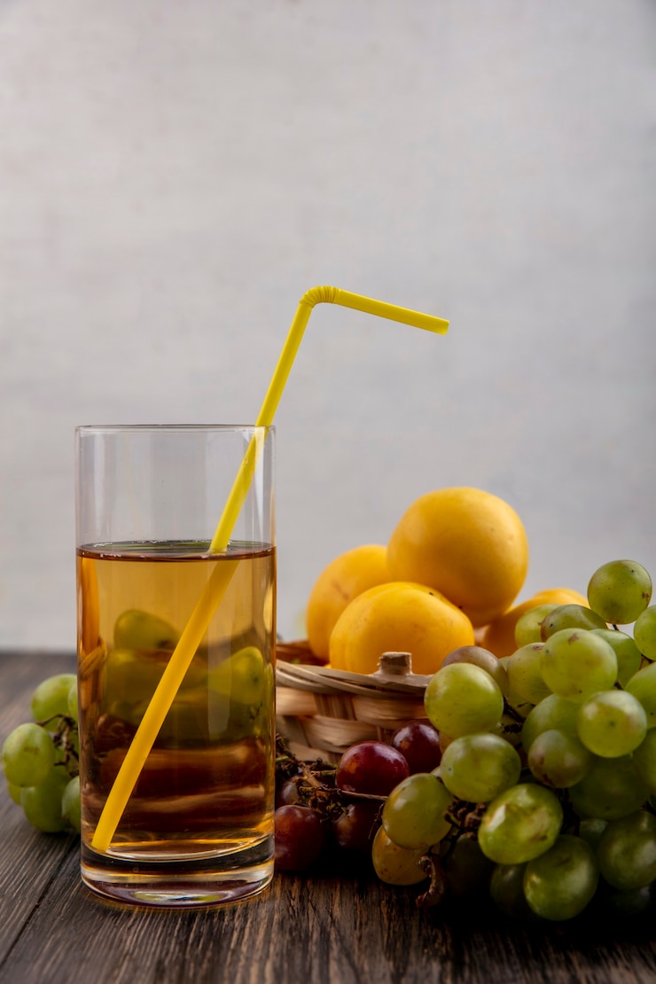 Free Photo side view of white grape juice with fruits as nectacots in basket with grapes on wooden background