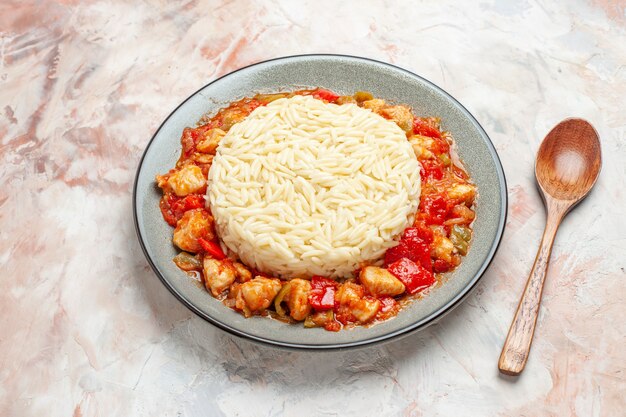 닭고기와 토마토 스푼을 곁들인 흰 일반 쌀 식사의 측면 보기