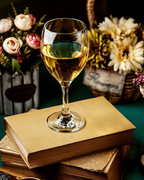 Side view of white wine in glass on book