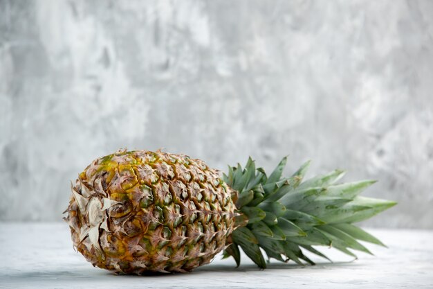 Side view of whole fresh falling golden pineapple on marble surface