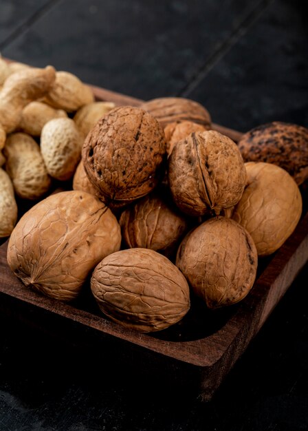 Side view of whole walnuts on a wooden tray
