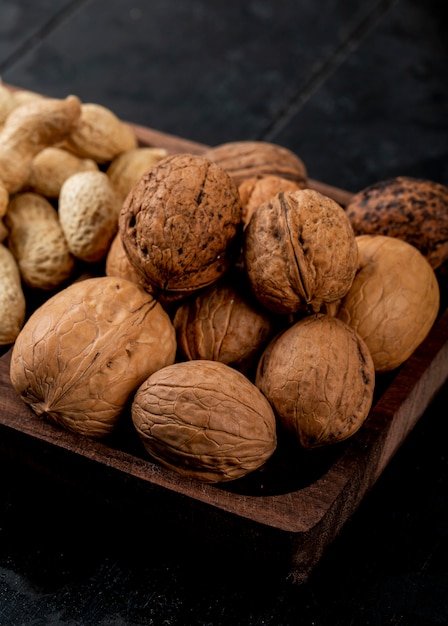 Side view of whole walnuts on a wooden tray