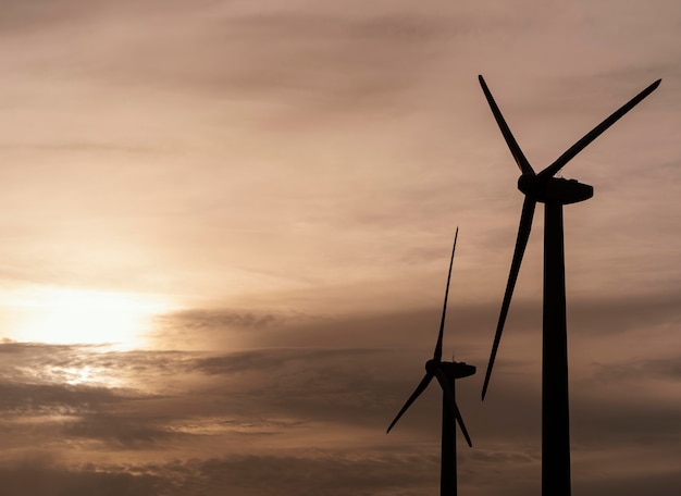 Foto gratuita vista laterale della silhouette della turbina eolica che genera elettricità