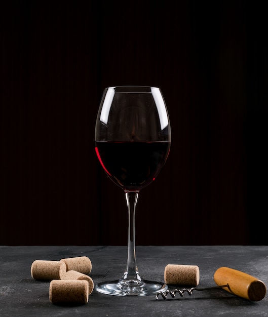 Free photo side view wine glass on dark table and vertical