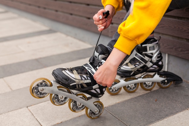 Free photo side view of woman adjusting roller blades