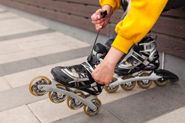 Side view of woman adjusting roller blades