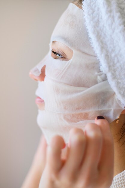 Side view of woman applying face mask