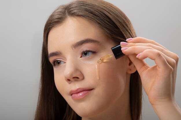 Side view woman applying serum