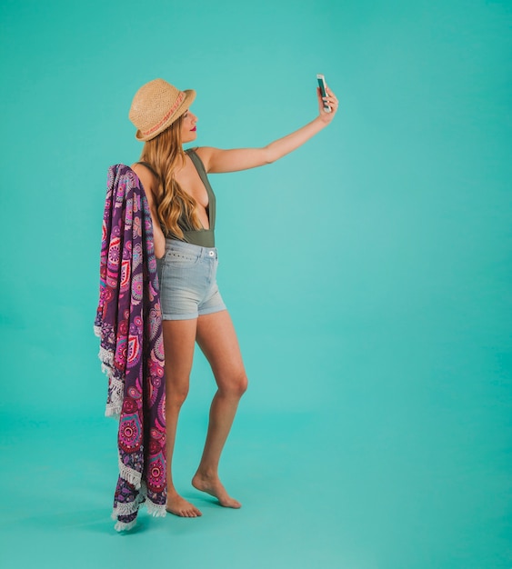 Side view of woman in beachwear taking a selfie