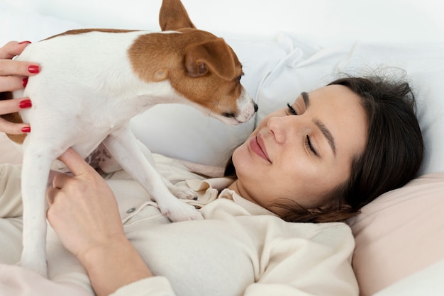 彼女の犬と一緒にベッドで女性の側面図