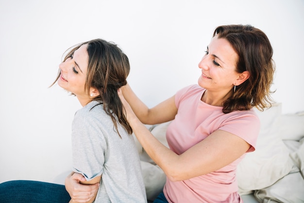 Side view woman braiding hair of woman