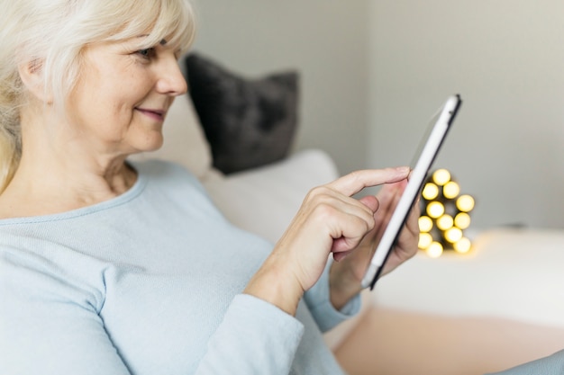 Free photo side view woman browsing smartphone