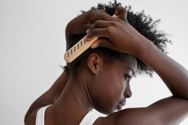 Side view woman brushing hair