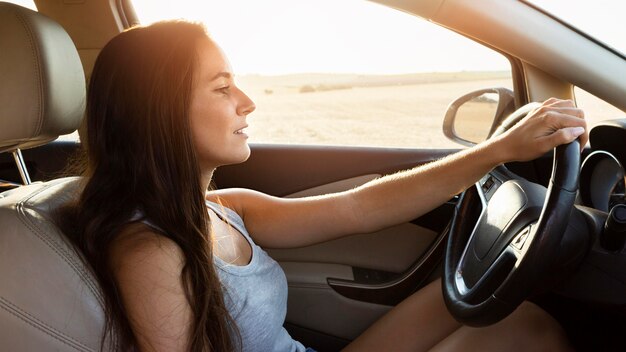 Side view of woman in the car on nature adventure