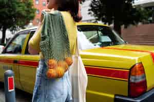 Free photo side view woman carrying fabric bags