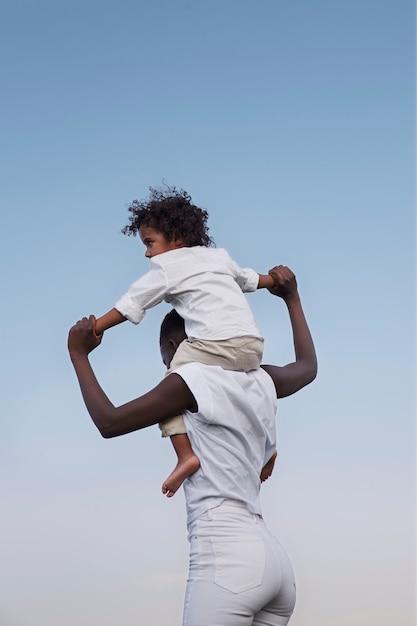 Side view woman carrying kid on shoulders