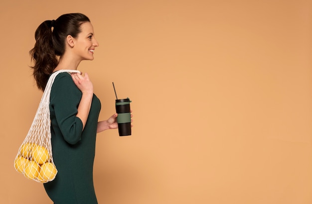 Side view woman in casual clothes carrying reusable turtle bag