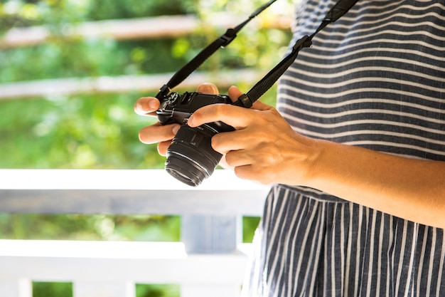 Foto gratuita donna di vista laterale che controlla le foto sulla macchina fotografica