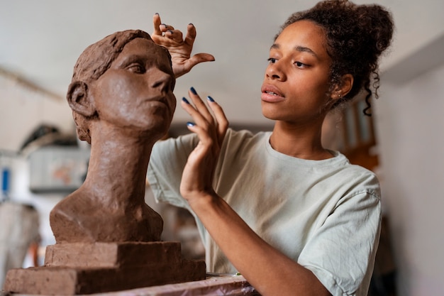 Foto gratuita scultura dell'argilla della donna di vista laterale