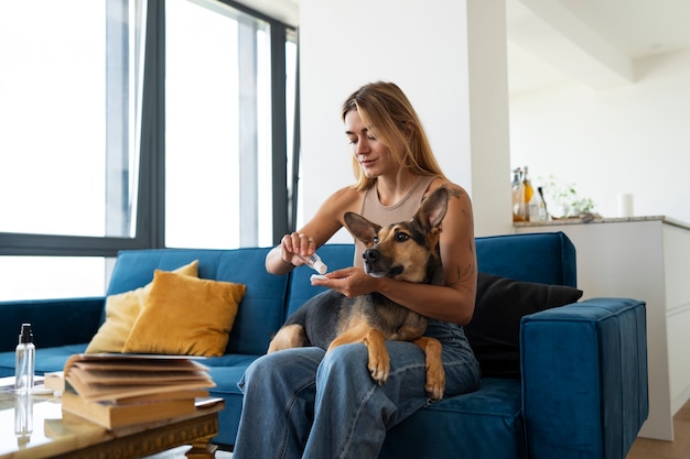 Free photo side view woman cleaning dog