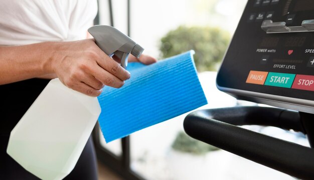 Side view of woman cleaning gym equipment