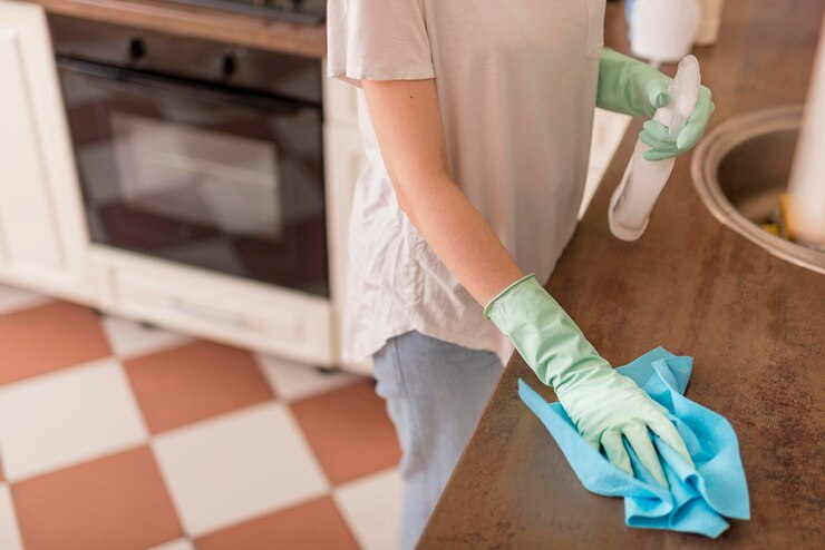 Free Photo side view of woman cleaning kitchen surface