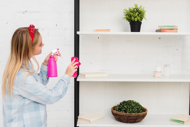 Side view woman cleaning shelves