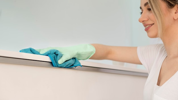 Free photo side view of woman cleaning surface