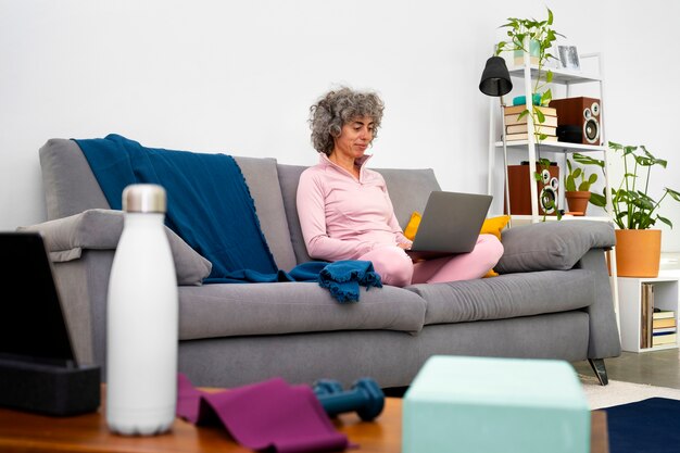 Side view woman on couch with laptop