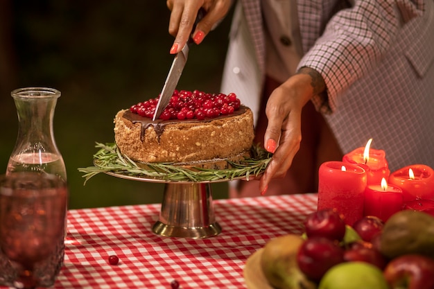 Free photo side view woman cutting cake