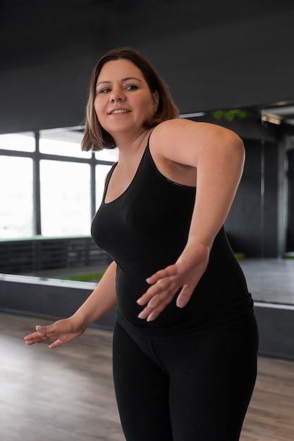 Free photo side view woman dancing in studio