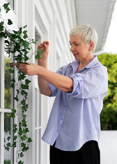 Side view woman decorating front door outside