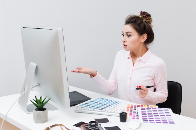 Side view of woman at desk looking at computer and not understanding what happened