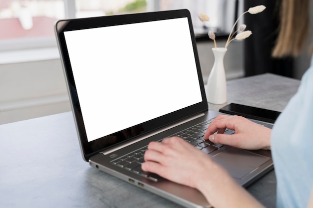 Side view of woman at desk working on laptop