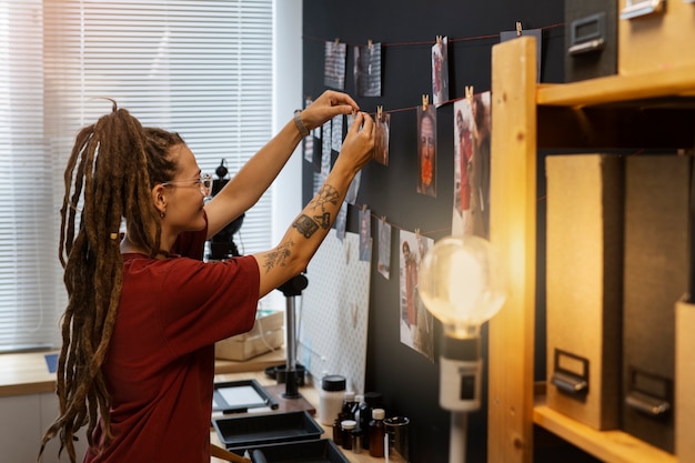 Side view woman developing photos in a darkroom