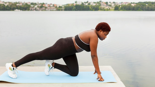 Side view of woman doing exercise by the beach