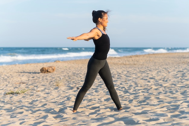Вид сбоку женщины, занимающейся фитнесом на пляже