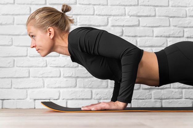 Free photo side view woman doing plank